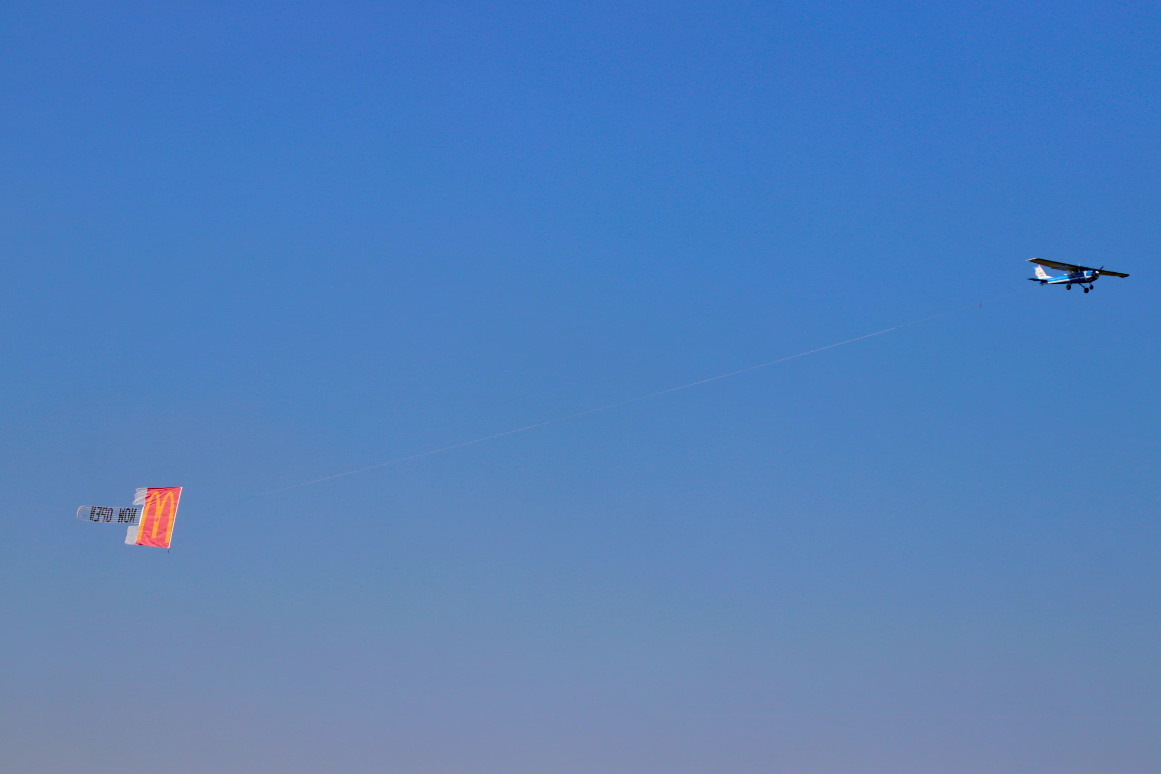 Aircraft towing a McDonald's combo banner across a clear blue sky
