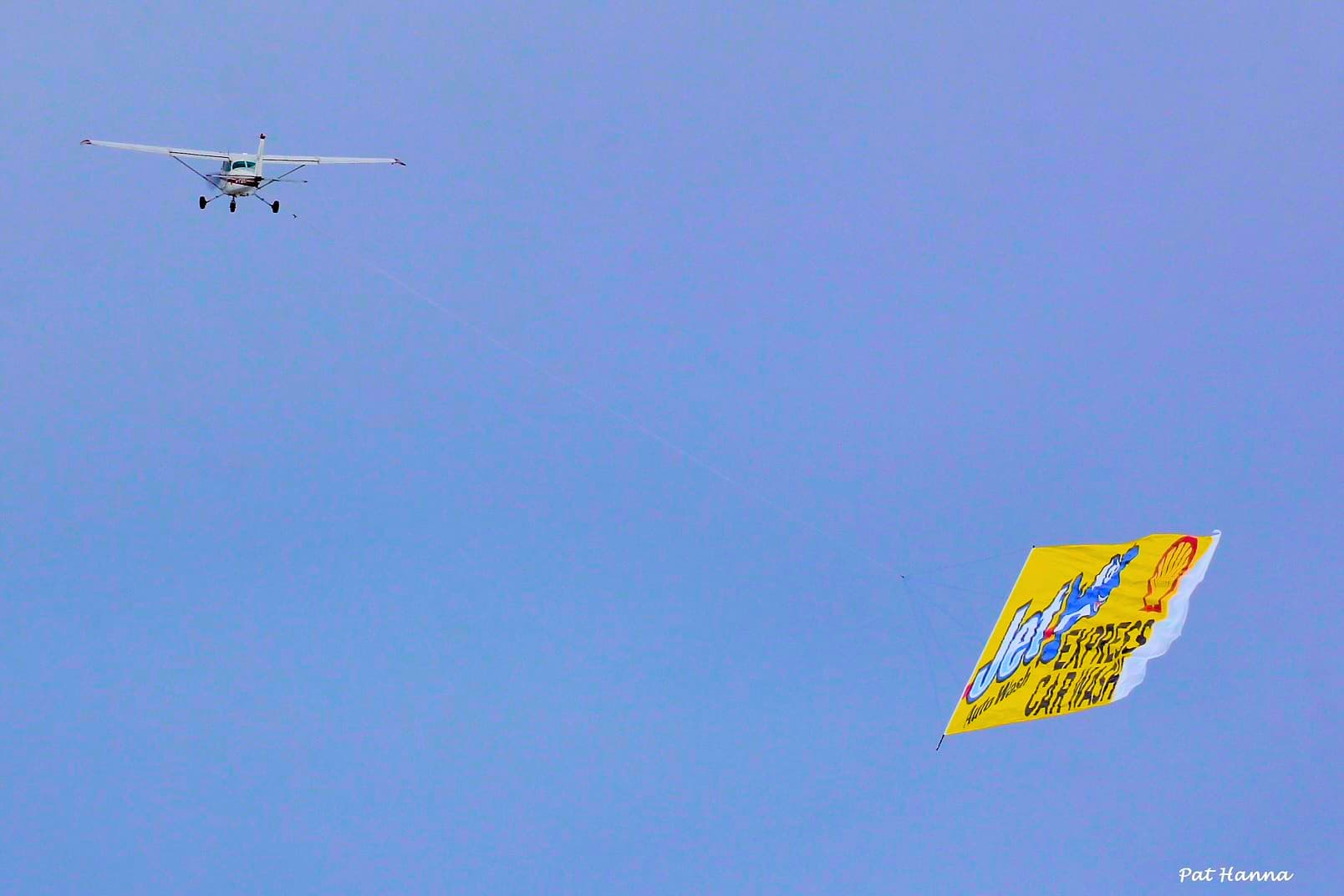Plane towing a Jet Express Car Wash billboard banner in the sky